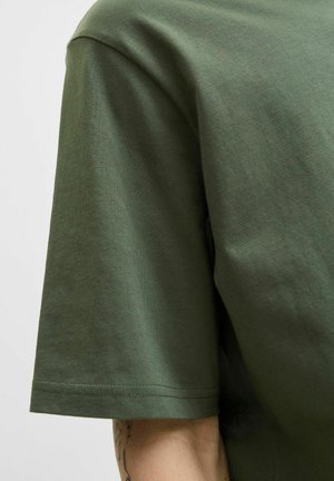 Kortærmet, olivengrøn bomulds t-shirt med rund hals, glat overflade og synlige sømme langs kanten og ærmerne.