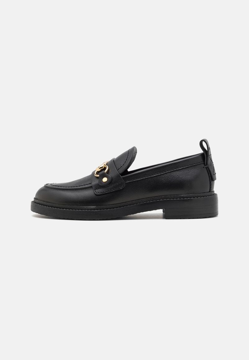 Mocassin en cuir noir avec détail en métal doré, talon bas et languette à l'arrière, présenté de profil sur fond blanc.