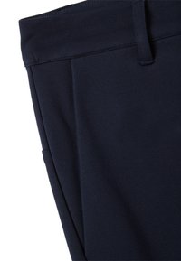 Pantalones azul marino hechos de tela elástica, con una textura suave, una cintura plana y un detalle de costura mínimo en los lados.
