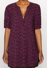 Vestido de manga corta en tejido azul oscuro con un patrón floral multicolor disperso. Escote en V y silueta relajada con aberturas laterales.
