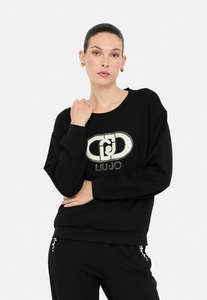 Zwarte sweatshirt met lange mouwen, ronde halslijn en sprankelend "LIU JO" logo. Zachte stof met een ontspannen pasvorm en versierde details op de broek.