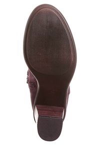 Botín de cuero morado oscuro con punta redonda y herrajes decorativos. Acabado suave, suela de madera y un tacón cuadrado moderado. Suela texturizada.