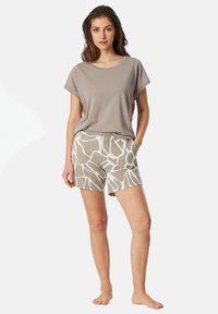 Light gray short-sleeve top and patterned beige shorts with abstract white shapes, made from soft, lightweight fabric. Casual design with side pockets.