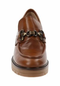 Mocasín de cuero marrón con suela gruesa y detalle de cadena de metal negro en la parte superior, mostrado desde la vista frontal sobre un fondo blanco.