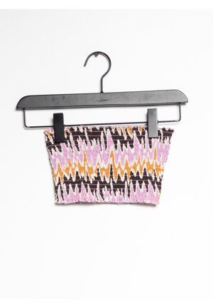 Haut court en tissu tricoté sur un cintre noir. Présente un motif en zigzag avec des couleurs rose, orange et marron. Matière élastique texturée.