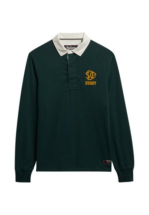 Ciemnozielona koszulka rugby z długimi rękawami, białym kołnierzykiem i haftowanym żółtym napisem "RUGBY". Posiada listwę i naszywkę z logo na końcu.