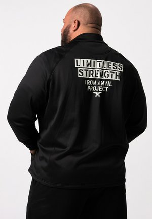 Sort langærmet træningsskjorte med "LIMITLESS STRENGTH" og "IRON ANVIL PROJECT" trykt i hvidt på ryggen. Glat tekstur.