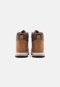 Bottines en simili cuir marron avec un haut rembourré, doublure en fourrure texturée marron et semelle stratifiée avec un détail de couture contrastant.