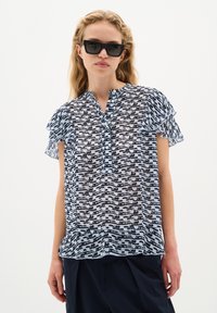 Blusa a maniche corte con un design a fantasia nero e azzurro chiaro, caratterizzata da una chiusura con bottoni e maniche arricciate. Tessuto trasparente.