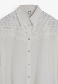 Camisa blanca con cuello, que presenta un diseño de fruncido texturizado en la parte superior y cierre de botones en la parte frontal.