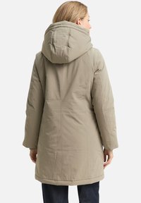 Hellbeige Steppmantel mit großer Kapuze, langen Ärmeln und leicht taillierter Passform, mit glatter, matter Textur.