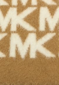 Tengere kokosmat met een wit logo patroon, gestructureerd oppervlak en een zachte, vezelige uitstraling met een dichte weving.