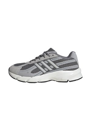 Zapatilla deportiva gris y blanca con parte superior de malla, cierre de cordones y suela blanca acolchada, mostrada de lado sobre fondo blanco.