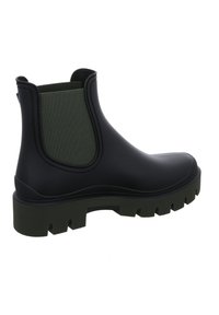 Botín negro de goma hasta el tobillo con paneles laterales elásticos verdes, suela texturizada y un dibujo grueso. Acabado liso con punta redondeada y tacón bajo.