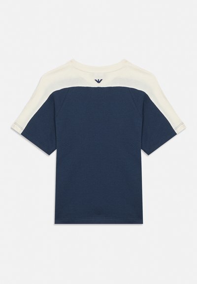 Marineblauw shirt met korte mouwen, wit schouderpanelen en een klein donker logo in het midden van de achterhals.