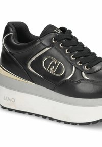 Sneaker platform nera in pelle con lacci neri, logo metallico sul lato, suola bianca e dettaglio dorato sul tallone.