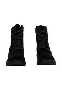 Black suede ankle boots with a high top, featuring front laces and side zippers, flat black rubber soles, and subtle stitching details.