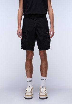 Zwarte cargoshorts met zijzakken, gemaakt van duurzaam materiaal. Gecombineerd met beige en witte sneakers. Eenvoudig ontwerp met een relaxte pasvorm.