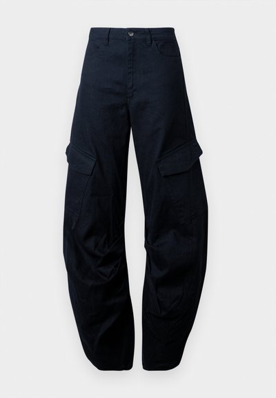 Calças cargo largas em azul marinho, feitas de algodão. As características incluem grandes bolsos laterais, fecho com botão e um design de perna afunilada.