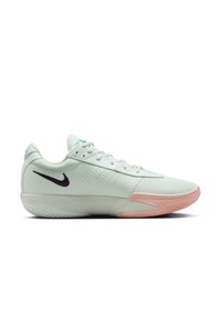 Baskets de sport vert clair avec tige en mesh, semelle rose et logo Nike swoosh noir. Caractéristiques d'un design épuré et d'une surface texturée.