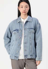 Denim jakna v svetlo modri barvi z udobnim krojem, s ovratnikom,-button spredaj, prsnih žepih in rahlo obrabljenim robom.