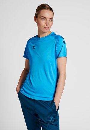 Lichtblauw sportshirt met korte mouwen en een ronde halslijn, voorzien van een zwart logo. Draagt bij navyblauwe broek met zijzakken en bijpassend logo.