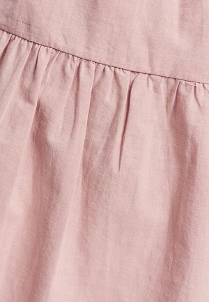 Tessuto rosa chiaro con una morbida texture, caratterizzato da dettagli arricciati in vita e leggere pieghe, che creano profondità nel design.