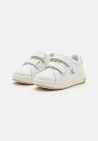 Białe sneakersy z dwoma rzepami, wykonane z miękkiej skóry, z różowymi akcentami na pięcie i beżową gumową podeszwą. Tekstura cielęcej skóry, casualowy design.