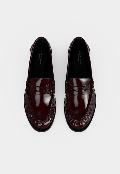 Paire de mocassins en cuir brillant bordeaux foncé avec surpiqûres moc toe, vue de dessus sur fond blanc.