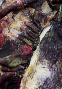 Lekka tkanina z nadrukiem, z falbankami na brzegach, o abstrakcyjnym wzorze w odcieniach ciemnej zieleni, fioletu, czerwieni i żółci.