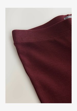 Burgundy bordázott anyagú leggings, sima derékpánttal, diszkrét vízszintes textúrával és rendezett varrásokkal az élein.