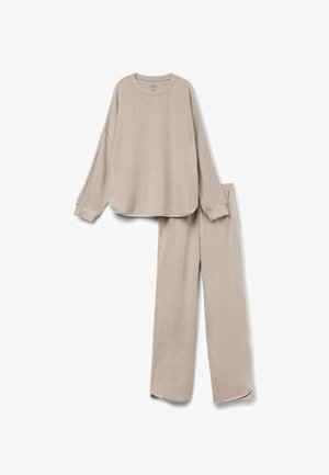 Set di lounge beige chiaro composto da una maglia a maniche lunghe, collo rotondo con orlo curvo e pantaloni dritti abbinati con spacco ai lati dell'orlo.