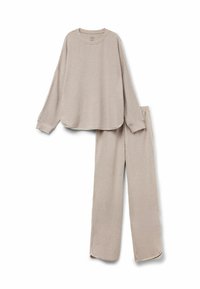Lys beige lounge sæt bestående af en langærmet, rundhalset bluse med buet nederkant og matchende lige ben bukser med sideslids ved kanten.