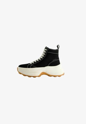 Czarny wysokiego kroju sneaker z grubą białą podeszwą, białymi sznurówkami, białym przeszyciem i brązową profilowaną podeszwą zewnętrzną.