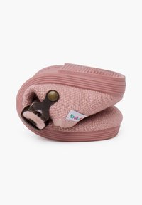 Zapatilla de tela rosa, texturizada con un diseño tejido, que cuenta con un detalle de hebilla marrón y un sutil logo en el lateral. Forma redondeada.