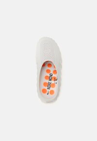 Λευκό παπούτσι τύπου slip-on με στρογγυλεμένη, κυματιστή σόλα. Διαθέτει διάτρητο επάνω μέρος και εσωτερική σόλα με πορτοκαλί πουά και σήμανση "NIKE".