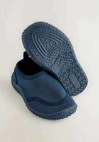 Scarpe slip-on blu navy con suola in gomma flessibile e strutturata e parte superiore liscia con dettagli di cucitura. Ideali per comfort e aderenza.