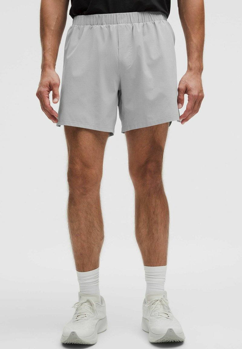 Pantalones cortos grises hechos de material ligero con una cinturilla elástica, que presentan un corte relajado y sin patrones ni acentos visibles.