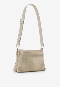 Borsa a tracolla beige con texture e finitura intrecciata, tracolla regolabile e hardware metallico. Forma rettangolare compatta, materiale in pelle morbida.