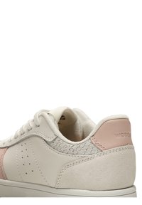 Zapatillas con un suave upper de piel blanco roto, ante rosa y acentos texturizados, con perforaciones y un collar acolchado.