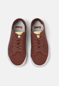 Sneaker in rete marroni con suole bianche, dotati di lacci, tomaia testurizzata e marchio 'CAMPER' in rosso su solette gialle.