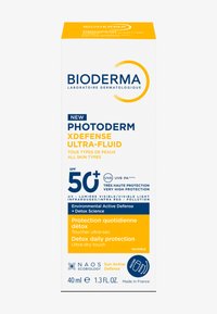 Écran solaire Bioderma Photoderm XDefense Ultra-Fluid. Boîte blanche avec texte jaune et bleu. Contient un SPF 50+, 40 ml. Conçu pour tous les types de peau.