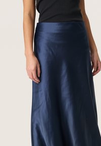 Gonna in satin blu navy con un design fluido. Tessuto morbido, taglio a lunghezza media, con una leggera lucentezza e una vita strutturata.
