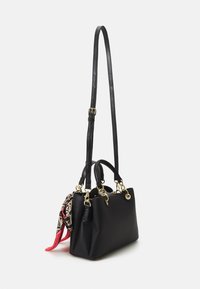 Sac à main en cuir noir avec une finition texturée, quincaillerie dorée, double poignées et une écharpe détachable avec un motif en rouge et beige.