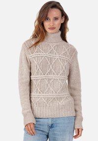 Pull beige en tricot avec un col montant, présentant des motifs texturés en diamants et des poignets côtelés. Matière en laine douce avec une coupe décontractée.