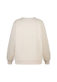 Crème sweatshirt met een ronde hals en lange mouwen. Mouwen hebben een textuur met parelversieringen langs de manchetten. Glad stoffen textuur.