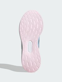 Semelle de chaussure avec un fond en caoutchouc rose texturé, présentant un insert circulaire proéminent et un design en vagues pour traction.