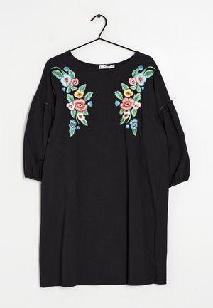 Vestido negro con bordados florales en rojo, rosa, azul y verde. Corte holgado con mangas abullonadas y escote redondo.