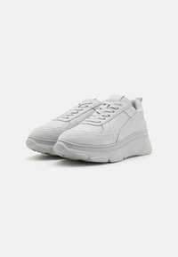 Witte sneakers met een combinatie van soepel leer en gestructureerd suede, een chunky zool, vetersluiting en een lusvormige hieltab.