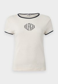 Μπεζ κοντομάνικο t-shirt με ναυτικό φινίρισμα. Διαθέτει το λογότυπο "HILFIGER" τυπωμένο με μαύρη καλλιγραφία στο μπροστινό μέρος. Μαλακό βαμβακερό υλικό.